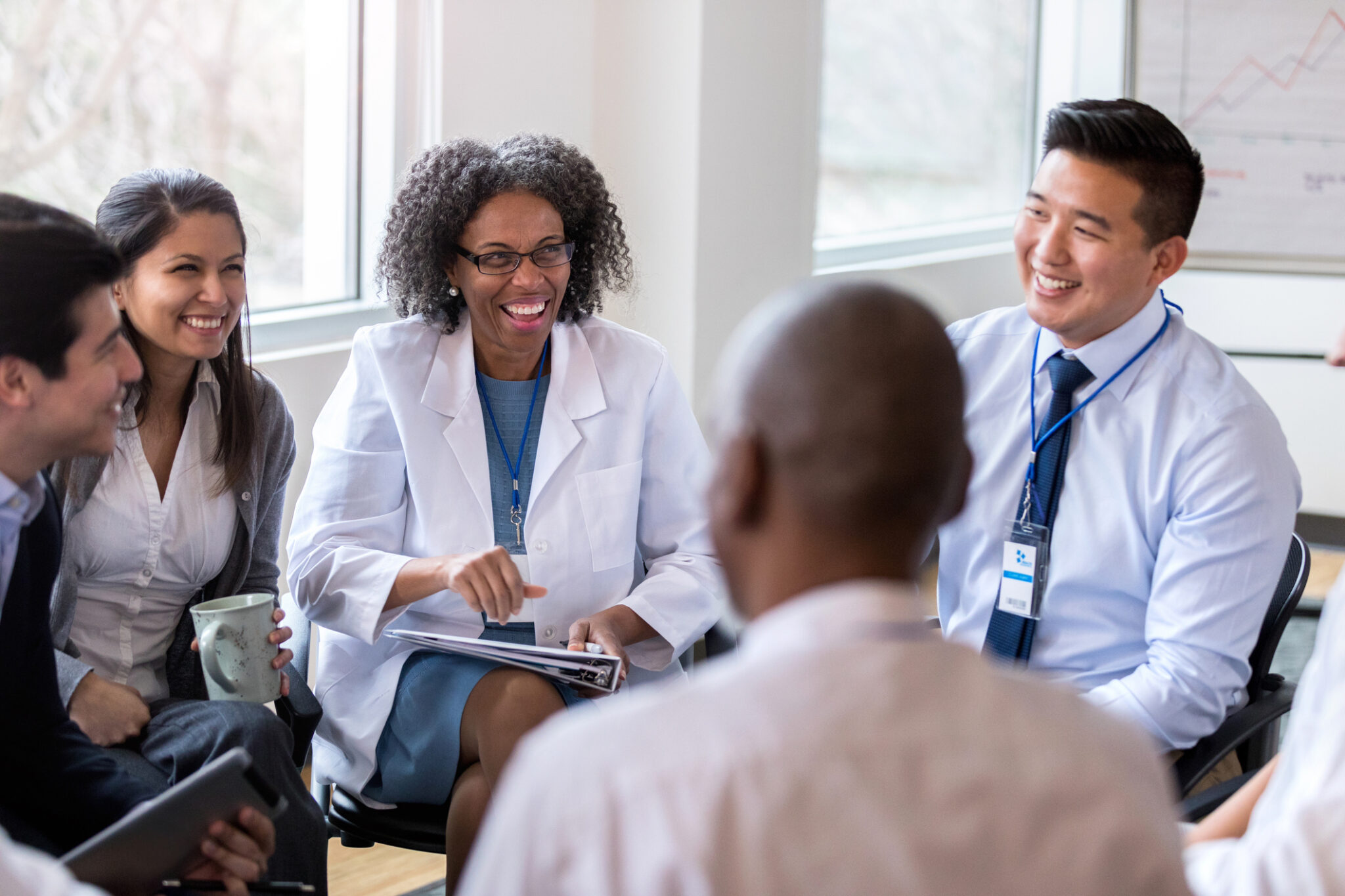 Cheerful medical coworkers enjoy staff meeting
